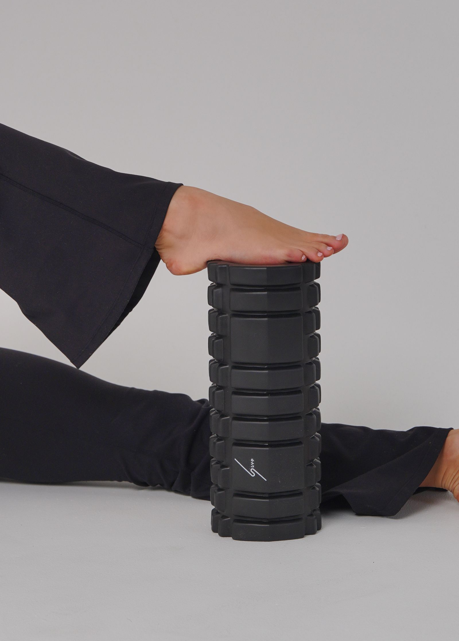 Athlete using a foam roller for lower-leg recovery — Massage Gun vs. Foam Roller: Which Recovery Tool Should You Buy First?