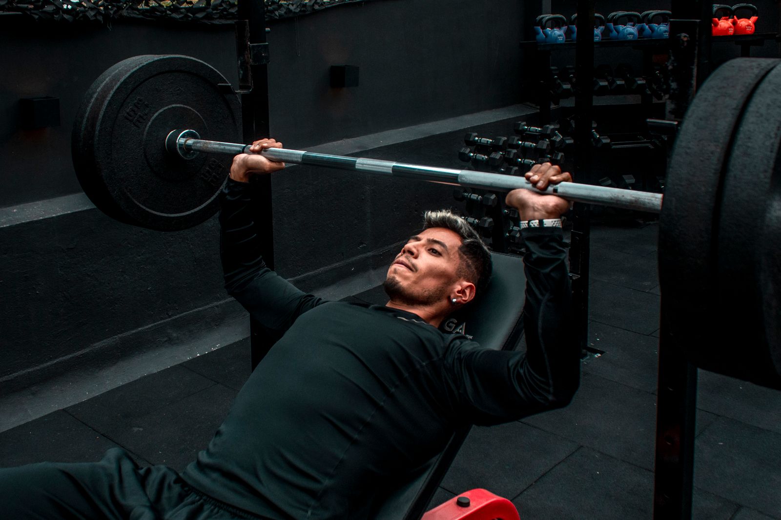 Athlete performing a barbell bench press in a gym — Products for Building Muscle: What Actually Helps and What to Buy First